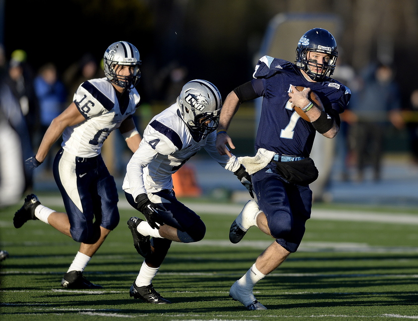 Maine quarterback Marcus Wasilewski eludes UNH defenders Nick Cefalo (16) and Manny Asam (4) as he runs for a first down during the second quarter of a second round playoff football game between UMaine and UNH at Alfond Stadium in Orono on Saturday.
