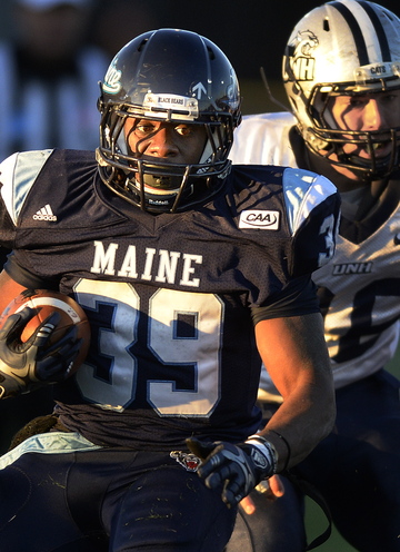 Rickey Stevens of Maine strides down the field in the fading afternoon light, away from Hayden Knudson of New Hampshire.