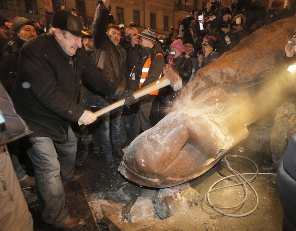 Ukrainians break a monument to Vladimir Lenin in center Kiev, Ukraine, on Sunday. The third week of protests continued Sunday with an estimated 200,000 Ukrainians occupying central Kiev to denounce President Viktor Yanukovych’s decision to turn away from Europe and align this ex-Soviet republic with Russia.
