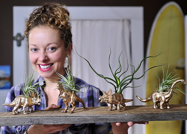 Brooke Hoerner with gold-painted dinosaur planters she creates in her Portland apartment. She’s filled hundreds of orders for them since they were highlighted in Real Simple magazine.