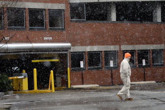 A pedestrian walks through light snow near the One City Center Parking Garage in Portland Monday. Walking became treacherous later.
