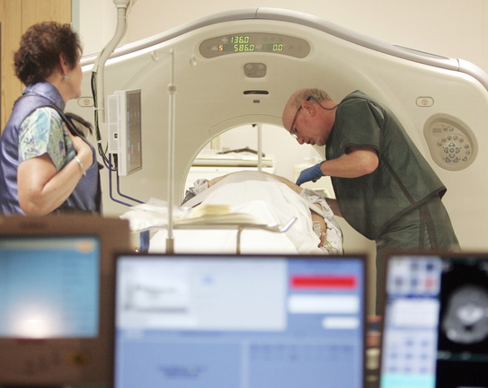 In this June 3, 2010, file photo, Dr. Steven Birnbaum works with a patient in a CT scanner at Southern New Hampshire Medical Center in Nashua, N.H. A national study suggests the world’s top cancer killer isn’t always as deadly as doctors once thought, finding that more than 18 percent of lung cancers detected in screening scans are likely so slow growing that they’d never cause problems. But the provocative results are unlikely to change how doctors treat lung cancer.
