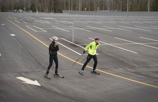 Ski team members Sam Alexander, right, a Yarmouth High School senior, and Emma Torres, a junior, roller-ski Sunday at the park-and-ride lot off Exit 15. They said the fresh asphalt, flat terrain and lack of obstacles make the lot a perfect place to roller-ski.