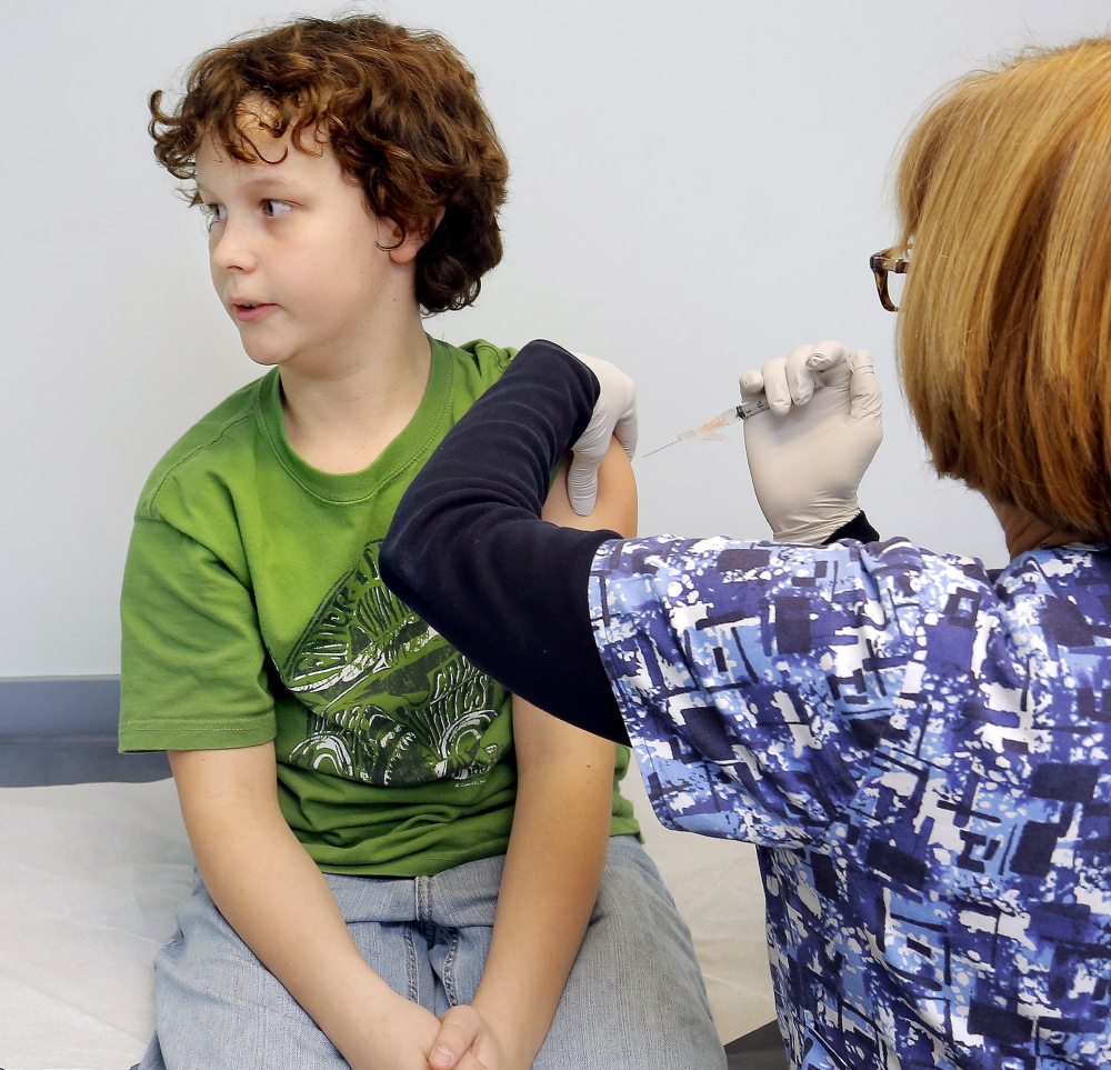 Nolan Davis, 11, of Hollis, looks away Tuesday as he receives a vaccination from nurse Becky Dyer at South Portland Pediatrics. Maine’s immunization rates for diseases such as tetanus, diphtheria, pertussis, measles and mumps improved significantly in 2012. “I’m relying on research rather than rumor” about the need for immunization, said Nolan’s mom, Crystal Davis. “We do it to try to prevent any kind of illness down the road.”