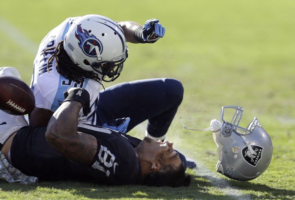 Oakland Raiders tight end Mychal Rivera loses his helmet after being hit by Tennessee Titans free safety Michael Griffin during a Nov. 14 game. Griffin was penalized on the play and served a one-game suspension for the hit.