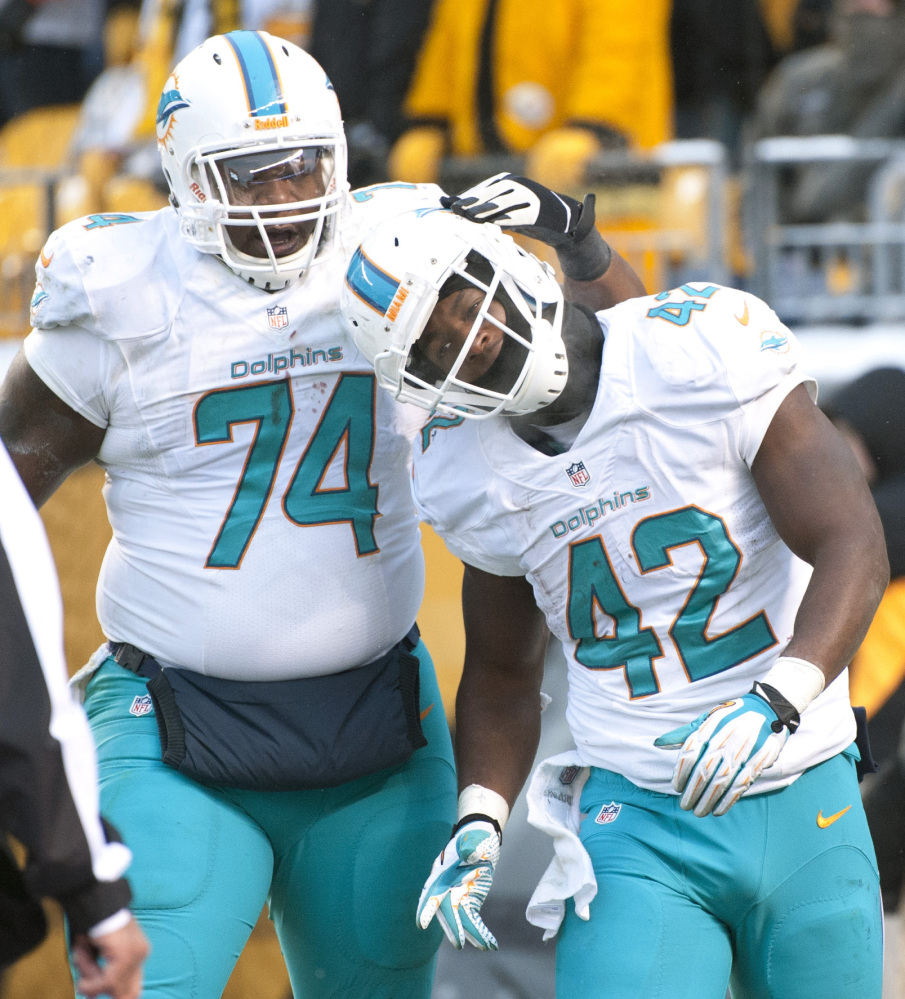 Miami Dolphins tight end Charles Clay, right, has been making a name for himself in recent weeks by eluding defenders like Pittsburgh’s Troy Polamalu.