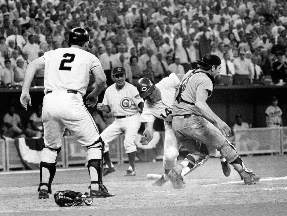 In this July 14, 1970 file photo, Cincinnati Reds’ Pete Rose (14) slams into Cleveland Indians’ catcher Ray Fosse to score a controversial game-winning run for the National League team in the 12th inning of the 1970 All-Star game in Cincinnati. Fosse suffered a fractured shoulder in the collision. Looking on are the Reds’ third base coach Leo Durocher, and Cincinnati Reds’ next hitter Dick Dietz (2). Major League Baseball plans to eliminate home plate collisions, possibly as soon as next season but no later than by 2015. New York Mets general manager Sandy Alderson, chairman of the rules committee, made the announcement Wednesday, Dec. 11, 2013 at the winter meetings. Player safety and concern over concussions were major factors in the decision.