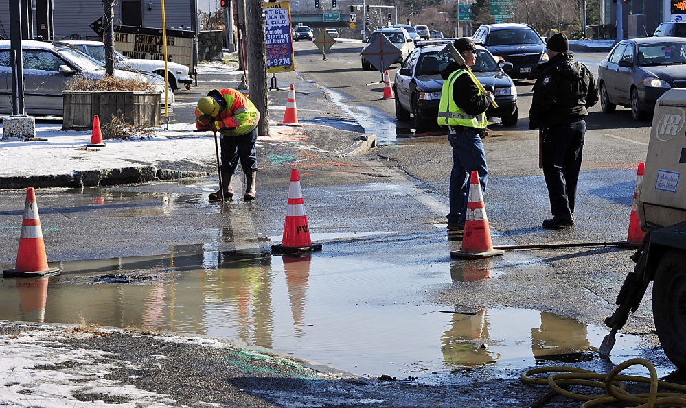 Gordon Chibroski/Staff Photographer Will Sparks of the Portland Water District listens as he shuts off one of the water valves on Bolton Street as a crew tries to determine where the water line break is.