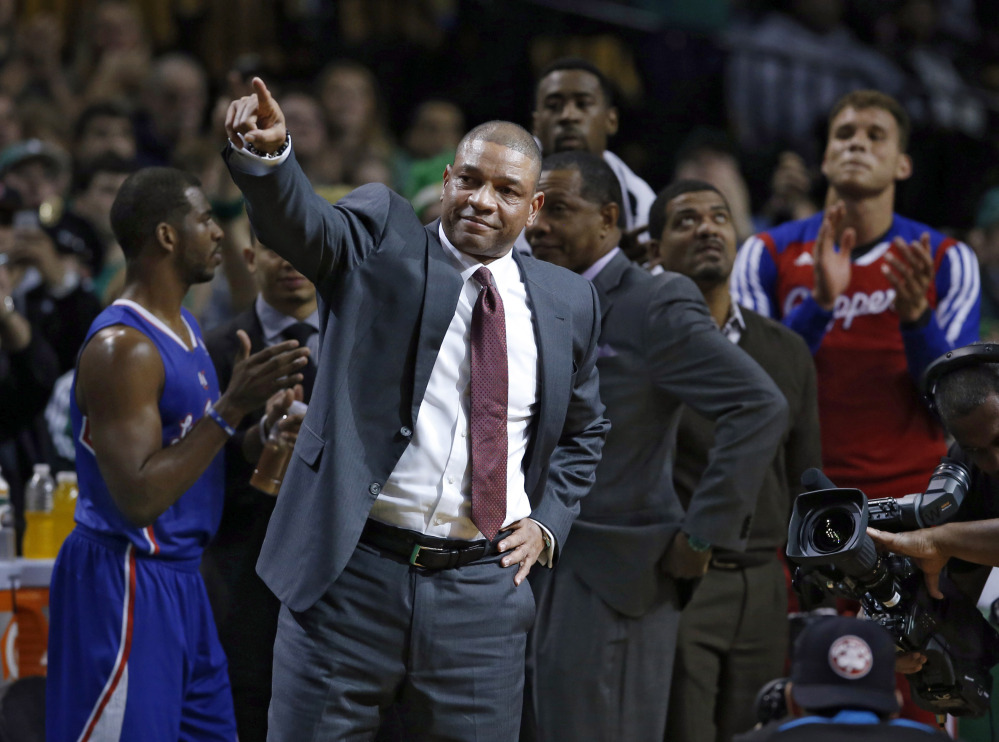 Doc Rivers, the former Celtics coach who is now head coach for the Los Angeles Clippers, points to acknowledge fans during a video tribute to him in his first time back on the sidelines at the TD Garden on Wednesday night.