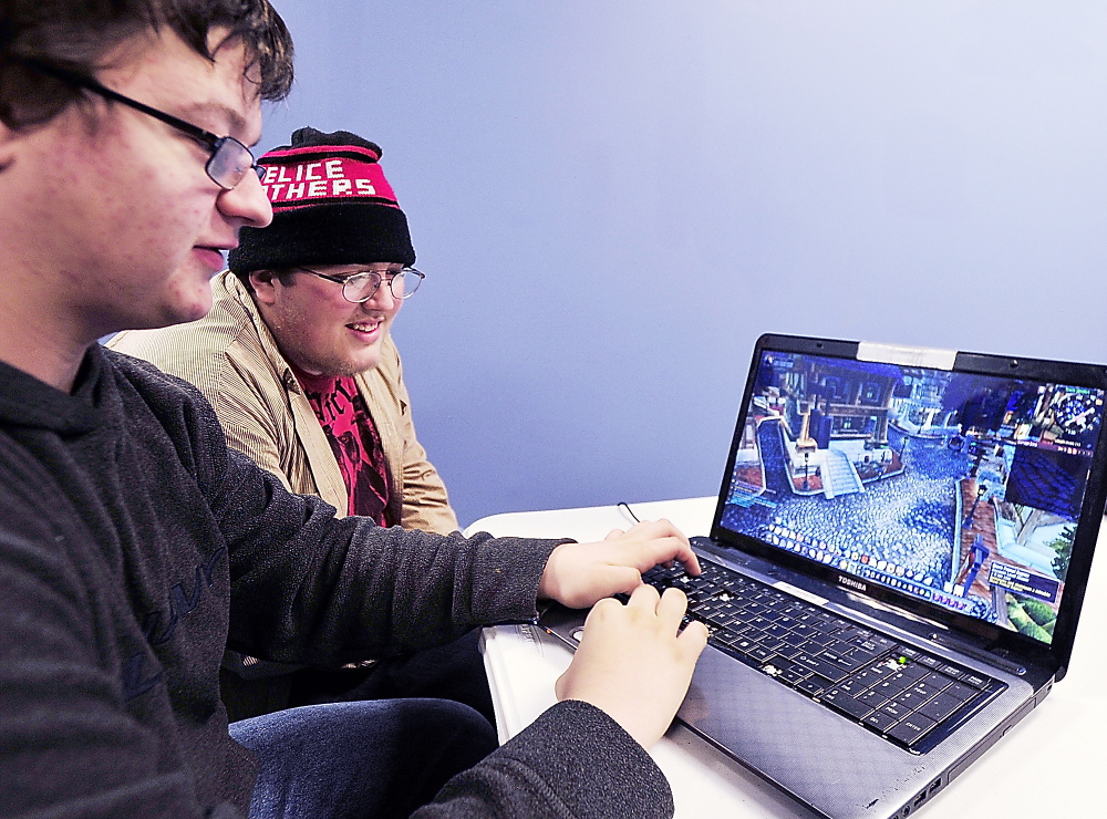 Victor Smith of Portland, left, plays his customized character with dozens of others online Thursday in “World of Warcraft.” Helping Smith with strategyis his friend, Keegan Beal.