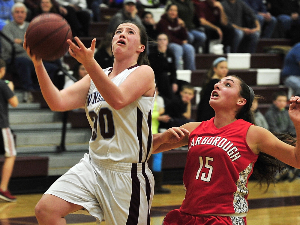 Sadie Nelson of Windham goes in for a fast-break basket as Emma Hall of Scarborough defends during their SMAA game Friday night in Windham. Nelson scored 20 points to lead the Eagles to a 48-43 win.