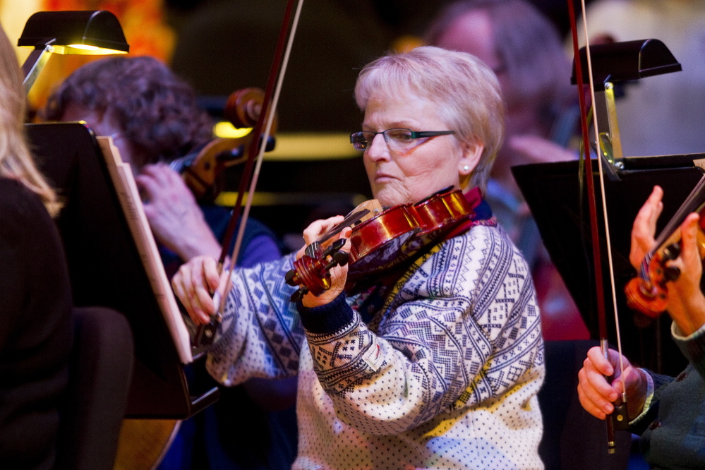 Carl D. Walsh/Staff Photographer Portland Symphony Orchestra violist Ann Stepp plays during the final “Magic of Christmas” at Merrill Auditorium in Portland on Thursday. Her daughter surprised her before the rehearsal by telling her she was also performing in the show.