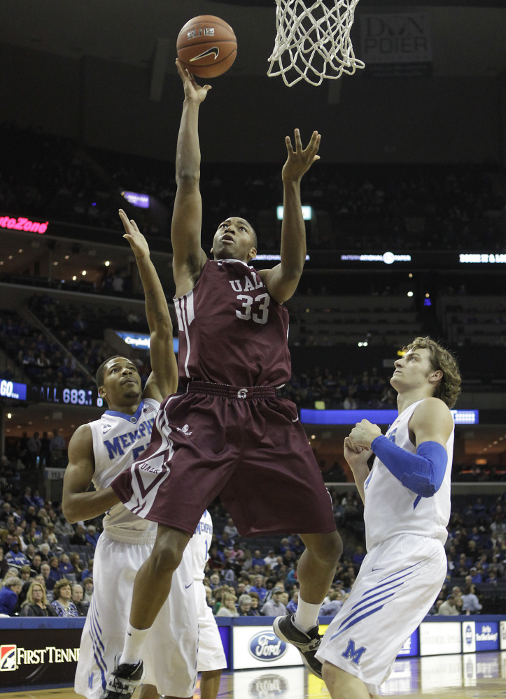 Arkansas-Little Rock forward James White goes to the basket between Memphis guard Geron Johnson, left, and forward Austin Nichols during Friday’s game in Memphis.