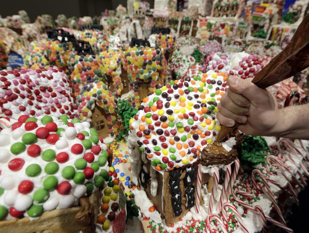 Chef and GingerBread Lane creator Jon Lovitch applies frosting to one of the gingerbread houses in the largest gingerbread village in the world according to the 2014 Guinness World Records. AP Photo