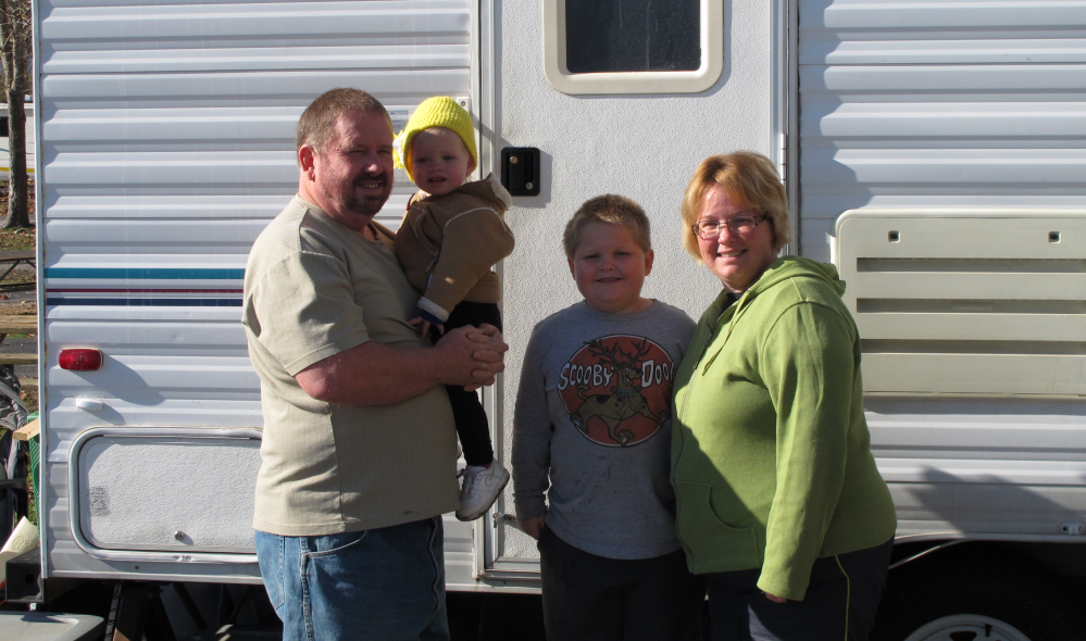 Ron and Kristin Dale and their children stand outside their 24-foot-long camper at a campground Thursday outside Campbellsville, Ky. The family is among many RV owners who converge on area campgrounds to take seasonal jobs at Amazon.com.