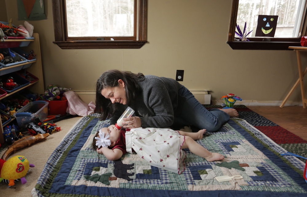 Meagan Patrick plays with her daughter, Addelyn, at their Acton home earlier this month. The baby has severe epilepsy, and the family is taking steps to try treating her seizures with a strain of medicinal marijuana not readily available in Maine.