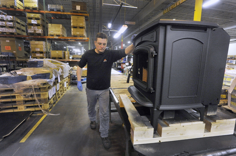 Jotul Stove employee Joe Osmond, who works at the Jotul North America plant in Gorham moves a finished stove down a conveyor line for final inspection and packaging.