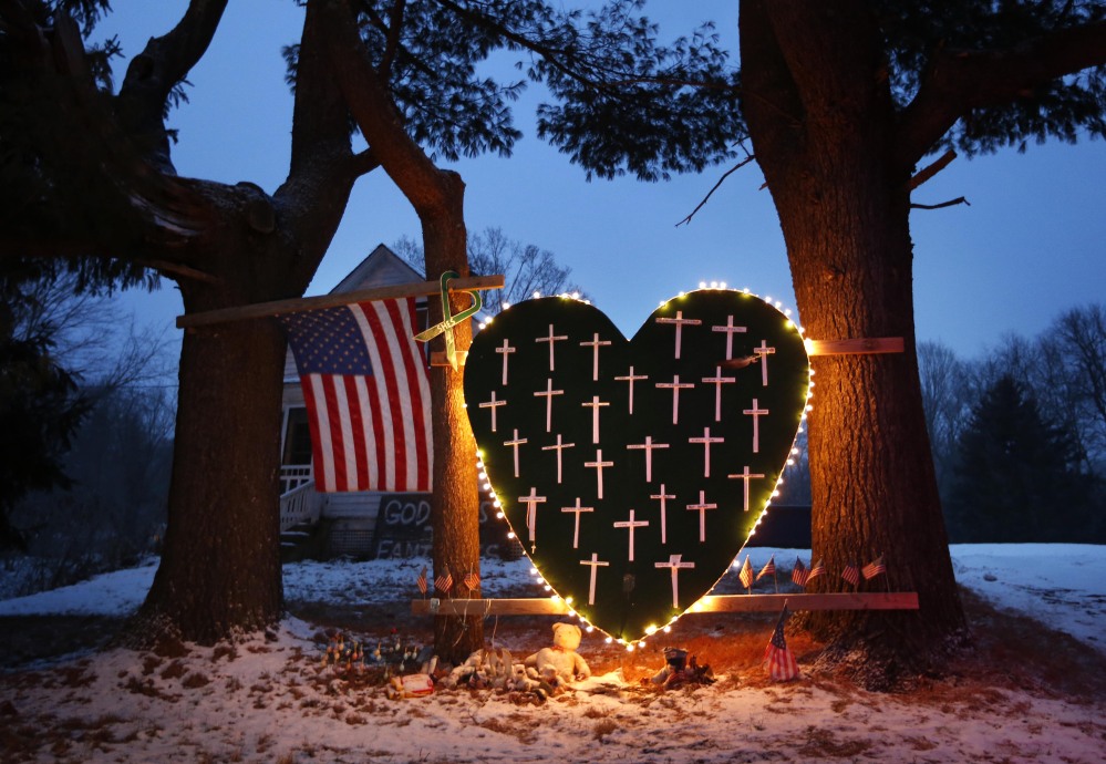 A makeshift memorial with crosses for the victims of the Sandy Hook massacre stands outside a home in Newtown, Conn., Saturday, Dec. 14, 2013, the one-year anniversary of the shootings.