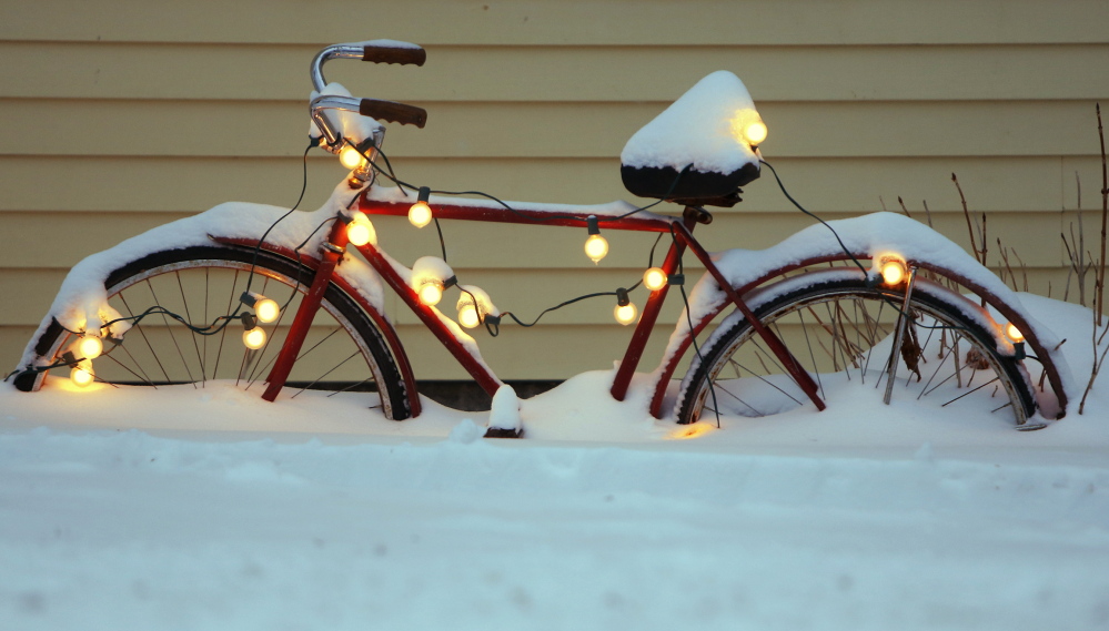 A bicycle decorated for the holidays at a home on Brown Street in Kennebunk is half-buried in snow from Sunday’s storm.