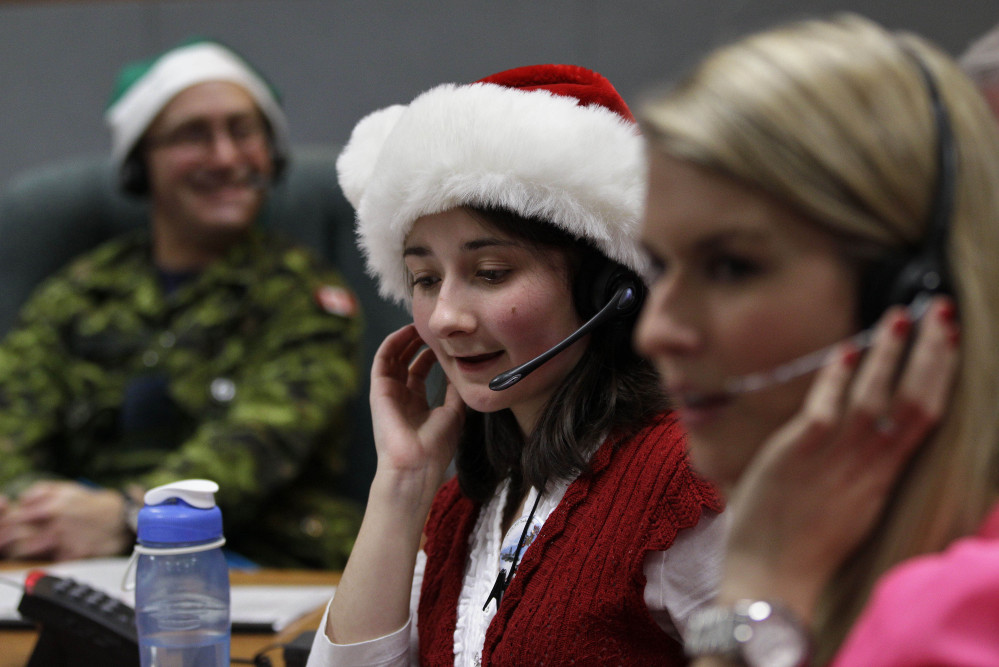 Volunteer Katherine Beaupre takes phone calls from children on Christmas Eve 2012 asking where Santa is and when he will deliver presents to their house,during the annual NORAD Tracks Santa Operation, at the North American Aerospace Defense Command, or NORAD, at Peterson Air Force Base, in Colorado Springs, Colo.
