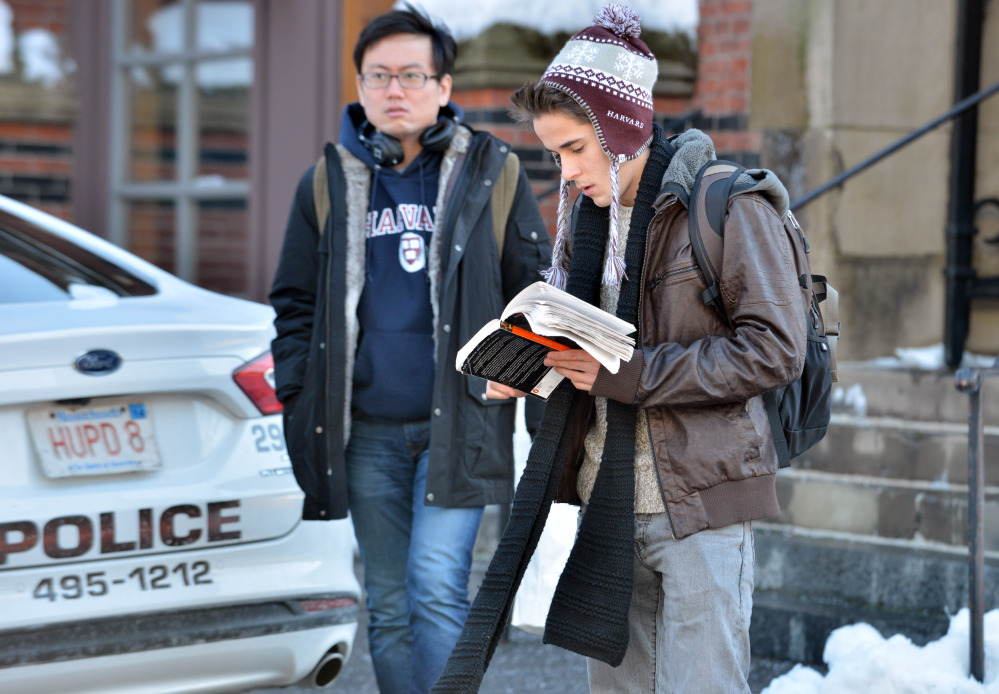 Students wait outside a building at Harvard University in Cambridge, Mass., Monday, Dec. 16, 2013. Four buildings on campus were evacuated Monday after campus police received an unconfirmed report that explosives may have been placed inside, interrupting final exams.