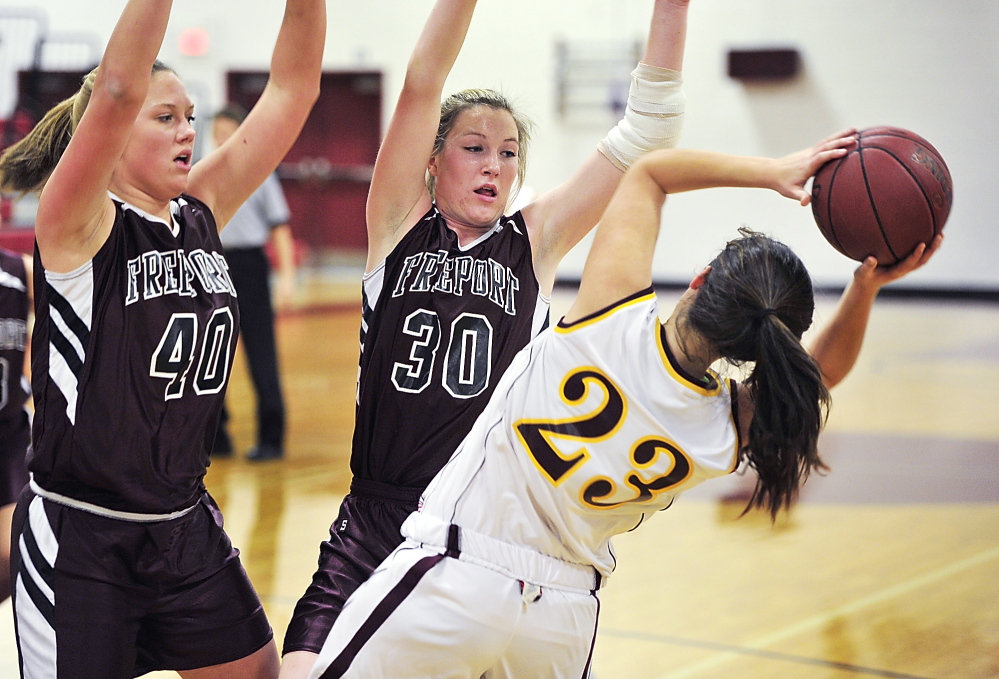 Emma O’Rourke of Cape Elizabeth gets trapped in the corner by Freeport’s Jessica Wall, left, and Nina Davenport. O’Rourke made 5 of 6 free throws in the fourth quarter to help the Capers secure their victory.