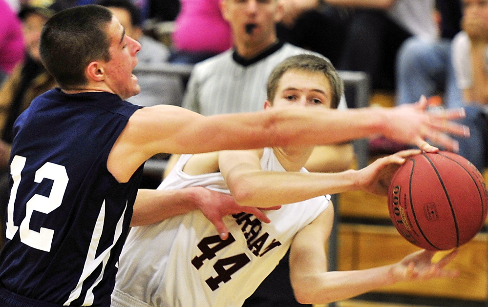 Billy Ruby of Gorham slips a pass under tough defense applied by Justin Zukowski of Portland during their SMAA game Tuesday night. Zukowski scored 15 points and the Bulldogs remained unbeaten through four games with a 60-40 victory.