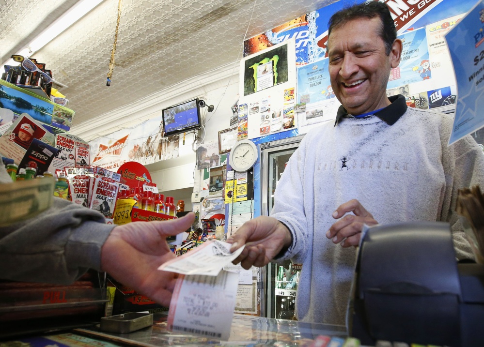 Keith Ganatra, owner of the Del Monte Market in Laveen, Ariz., sells Mega Millions lottery tickets on Tuesday. With tickets selling well, the jackpot for tonight’s drawing is now at an estimated $636 million – the second-biggest lottery prize in U.S. history.