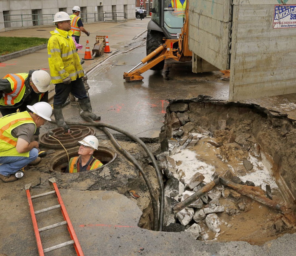 Central Maine Power and Portland Water District workers deal with a water main break in June. The district wants to raise rates to pay for replacement of aging pipes.