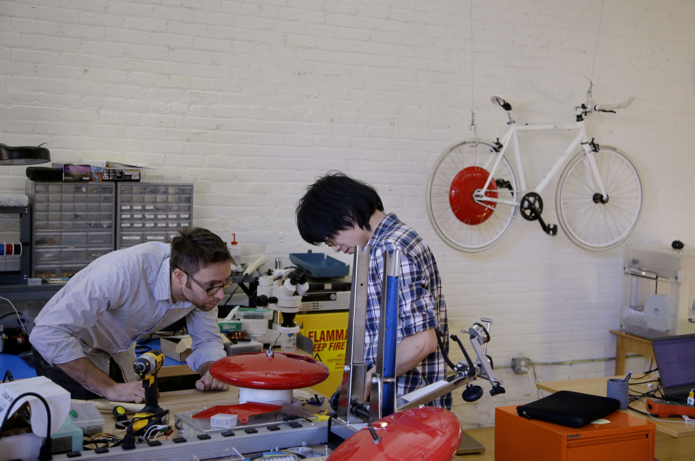 Mechanical and software engineer Julian Fong, right, and vehicle design engineer Jon Stevens work on a development to the Copenhagen Wheel.