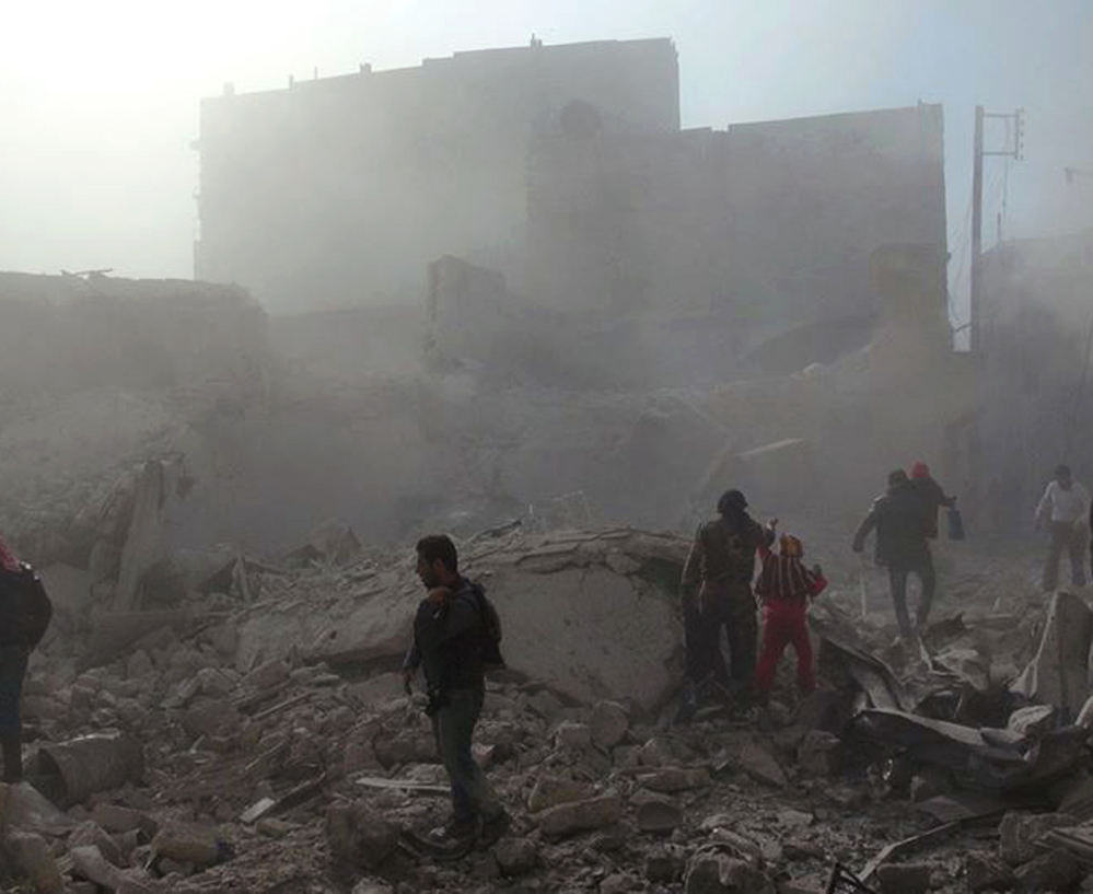 People inspect the rubble Tuesday following four days of Syrian government airstrikes in Aleppo, Syria. In a relentless offensive, helicopters dumped bombs packed with explosives and fuel on rebel-held neighborhoods.