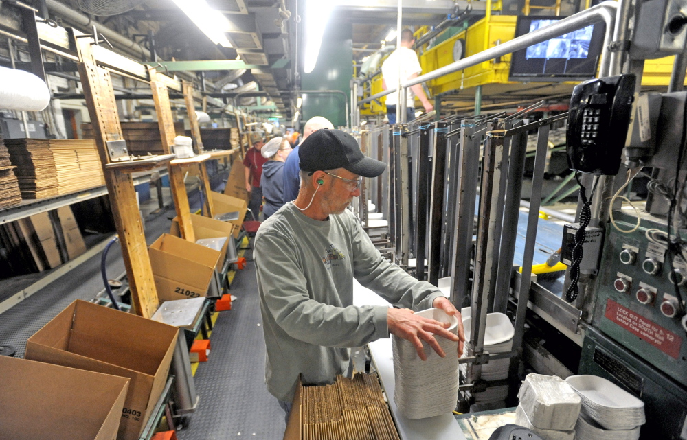 Mike Hamel stacks paper products during his shift at Huhtamaki in Waterville on Wednesday.