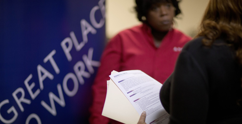 Jimmetta Smith of Lithonia, Ga., right, the wife of a U.S. Marine veteran, holds her resume while talking with Rhonda Knight, a recruiter for Delta Air Lines, at a job fair last month for veterans and relatives in Marietta, Ga.
