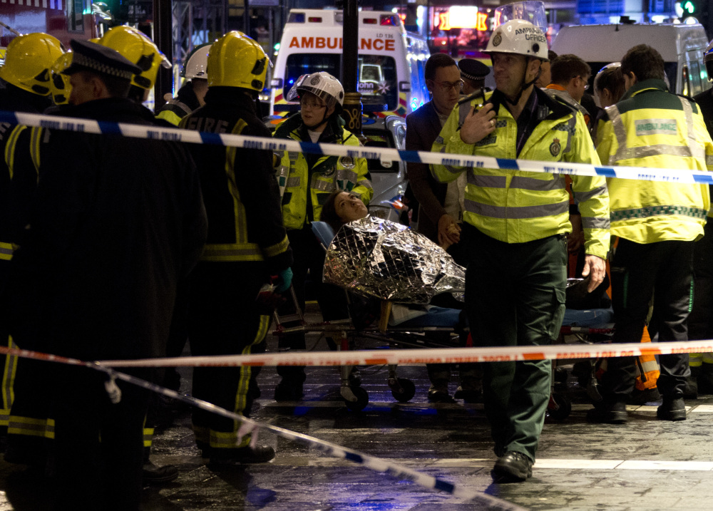 A woman lies on a stretcher surrounded by rescue workers, awaiting evacuation following an incident during a performance at the Apollo Theatre, in London’s Shaftesbury Avenue, Thursday evening, Dec. 19, 2013, with police saying there were “a number” of casualties. It wasn’t immediately clear which part of the building had collapsed. The London Fire Brigade said the theatre was almost full, with around 700 people watching the performance. A spokesman added: “It’s thought between 20 and 40 people were injured.”