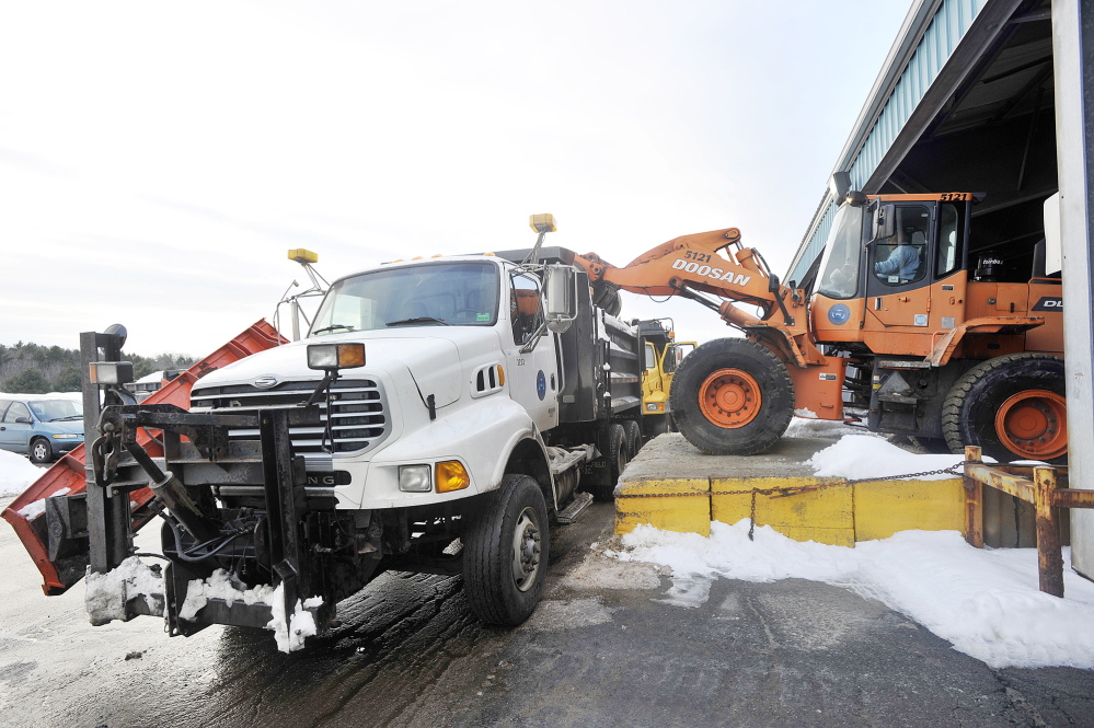Portland city workers load salt and sand trucks as a storm approaches.