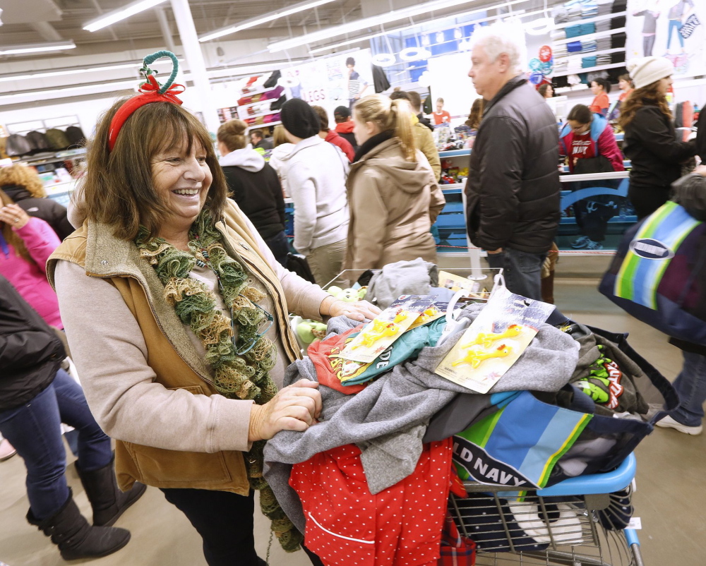 Barbara Adjutant of Biddeford rolls her cart through a long line at Old Navy in South Portland shortly after midnight Friday, Nov. 29. Nationwide stores are planning a sales blitz to finish the holiday shopping season, including round-the-clock hours.