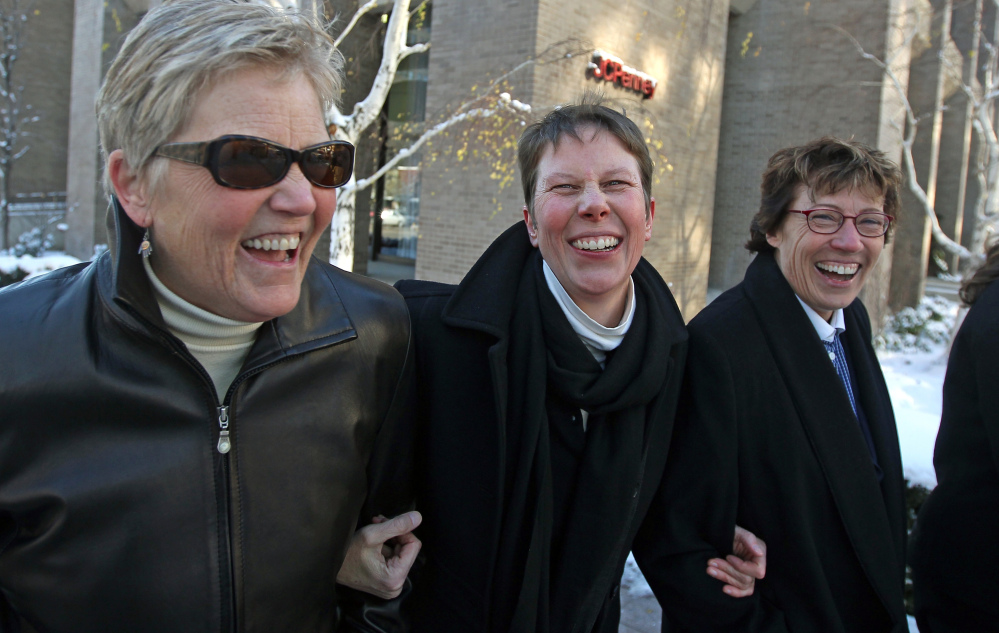 Laurie Wood, left, and her partner, Kody Partridge, center, walk with their attorney Peggy Tomsic after leaving the courthouse in Salt Lake City on Dec. 4. A federal judge struck down Utah’s same-sex marriage ban Friday.