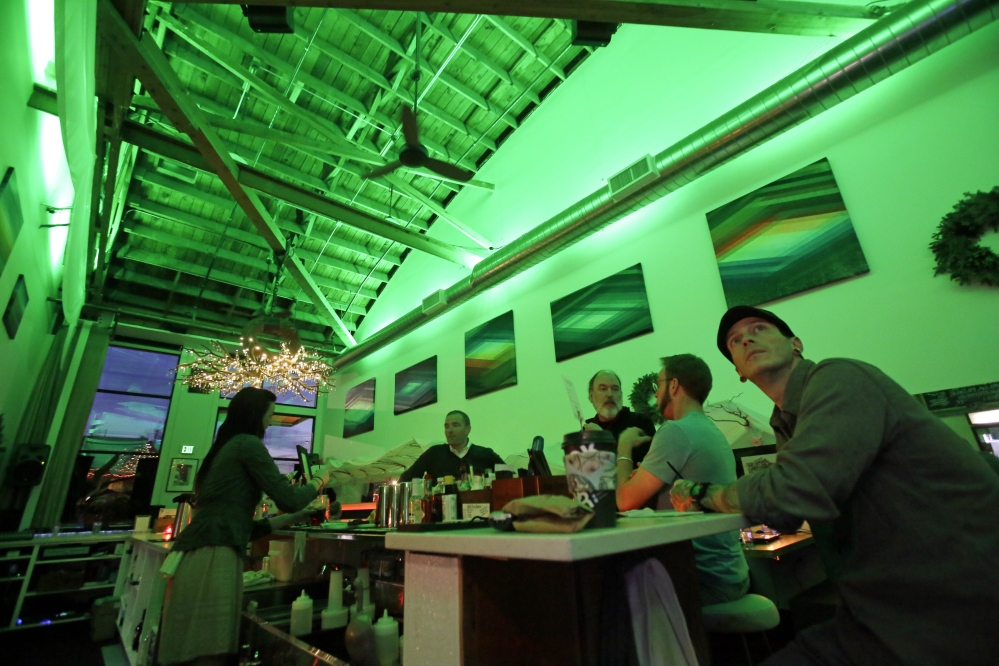 Lightbar patrons sit in a green glow from special lights in Portland, Ore., on Thursday. Designed to mimic sunlight, light boxes help those with seasonal affective disorder.