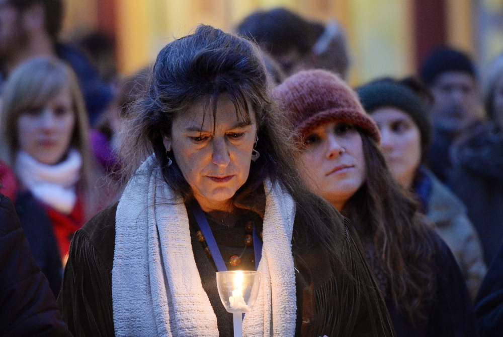 Above, Donna Yellen of the Preble Street Resource Center holds a candle. At right, Rebecca Dennison attends the vigil in memory of her friend, Mary Lou, who died recently.