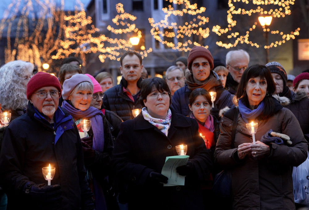 A crowd takes part in the annual memorial vigil for the homeless at Monument Square in Portland on Friday.