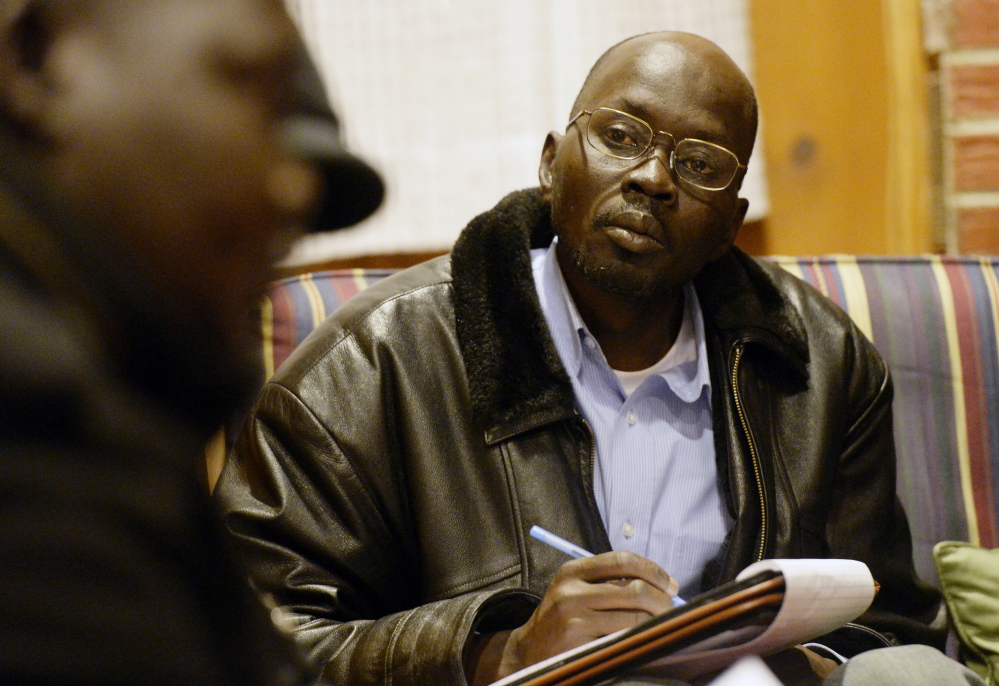 Mariano Mawein, chairman of a Maine Sudanese group, takes notes during a meeting of elders Saturday at a Portland church. Mawein said the elders agreed that South Sudan’s president instigated the conflict and should resign immediately.