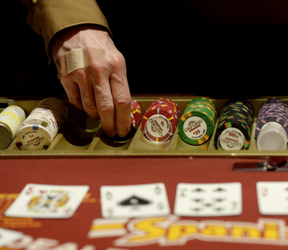 A dealer hands out chips at an Oxford Casino blackjack table. The table games at the casino bring in about $100,000 a month for the state Education Department.