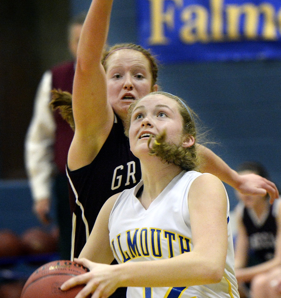Emma Powers of Falmouth drives to the basket as Greely’s Haley Felkel defends during their Western Maine Conference basketball game Saturday. Falmouth won, 53-45.