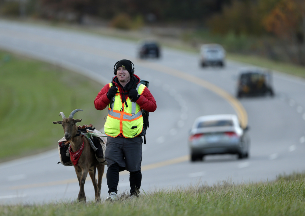 Steven Wescott walks with his goat, LeeRoy Brown, along a street in Lenexa, Kan., last month. The two have been walking since May 2, 2012, from Seattle to New York City to raise money for an orphanage in Kenya.
