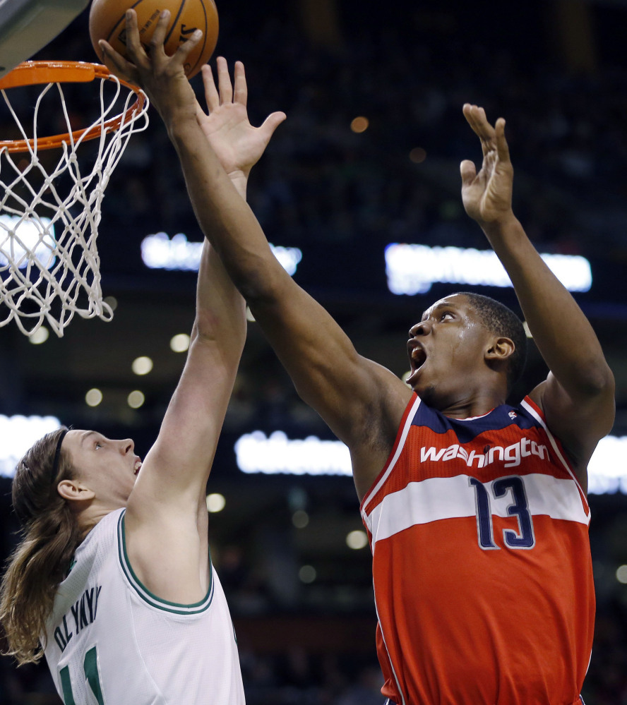 Kevin Seraphin of the Washington Wizards lifts the ball over Kelly Olynyk of the Boston Celtics for a second-quarter basket Saturday in Washington’s 106-99 victory.