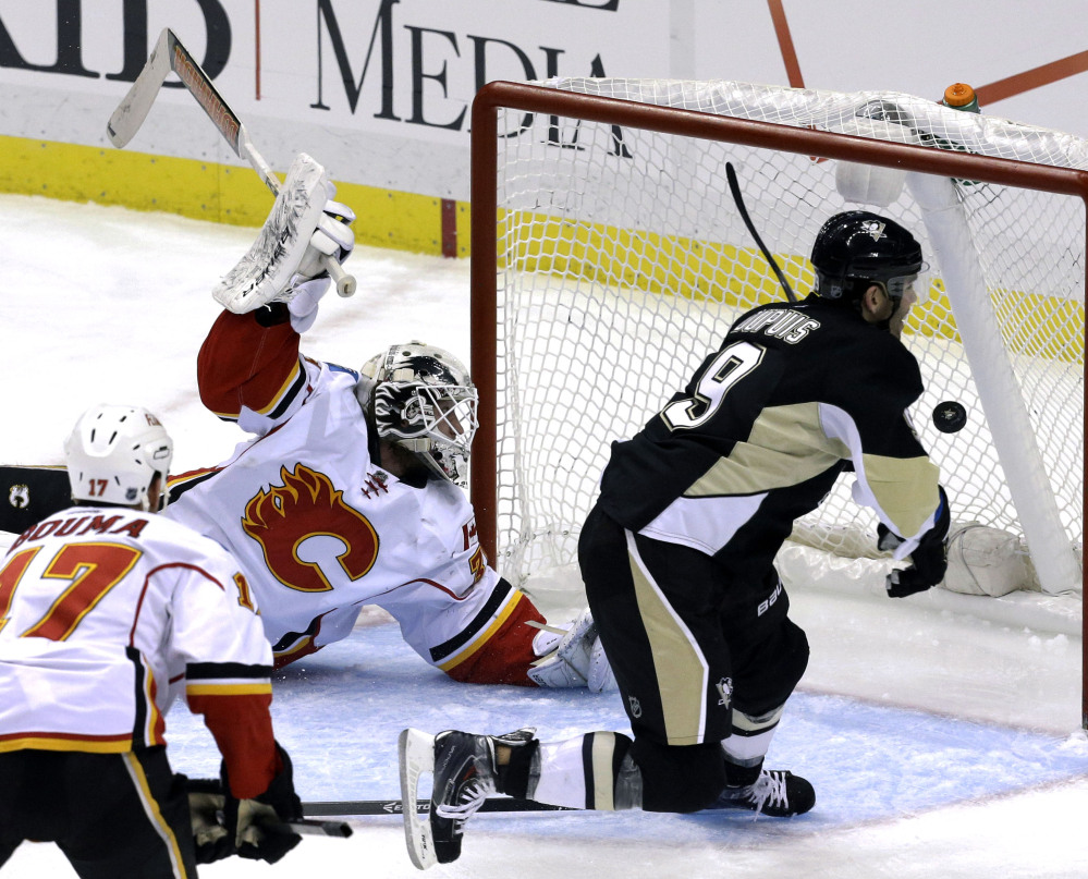 Pittsburgh’s Pascal Dupuis has a whole net to put the puck into as Calgary goaltender Karri Ramo is way out of position during Saturday afternoon’s game in Pittsburgh.