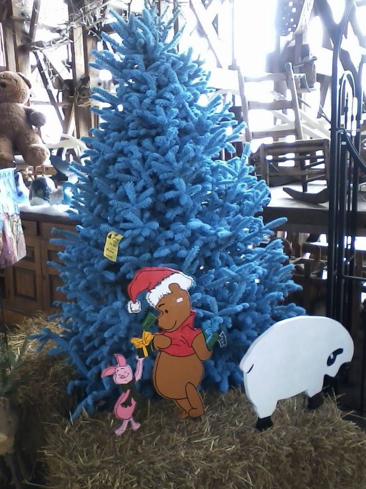 Holiday cutouts for indoor and outdoor use accent a blue-flocked Christmas tree at Charlie’s Produce and Nursery in York County, Va.