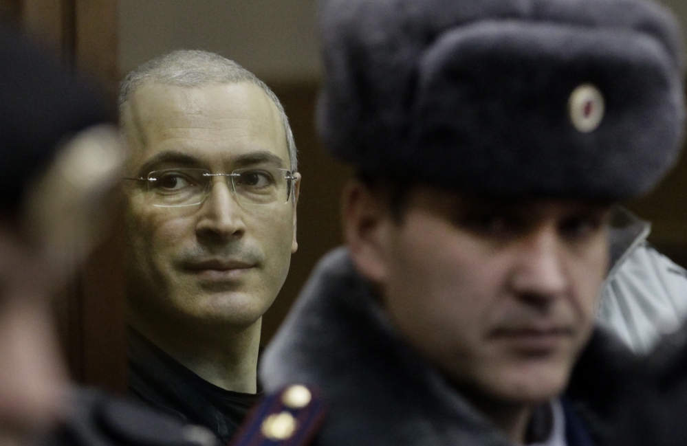 Mikhail Khodorkovsky, left, looks from behind glass in a Moscow courtroom in 2010. Jailed for a decade on tax evasion and embezzlement charges, the former oil baron and Putin critic was released Friday and reunited with his family on Saturday.