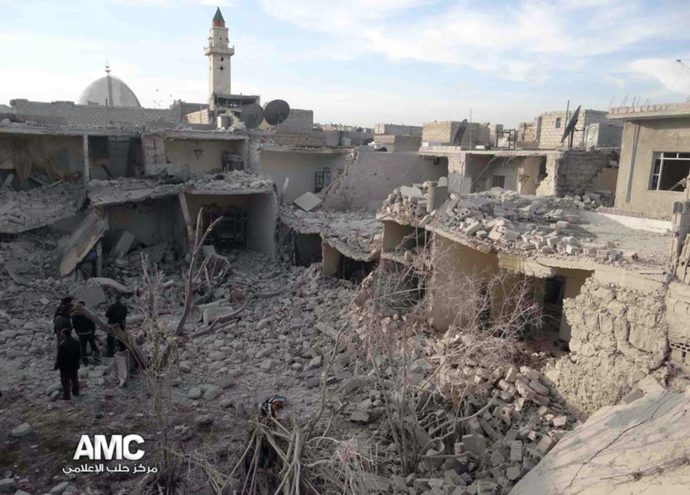 Syrian citizens stand on rubble of houses that were destroyed due to Syrian forces airstrikes in Aleppo, Syria. Syrian government aircraft dumped barrels packed with explosives on at least four opposition-held neighborhoods of Aleppo.