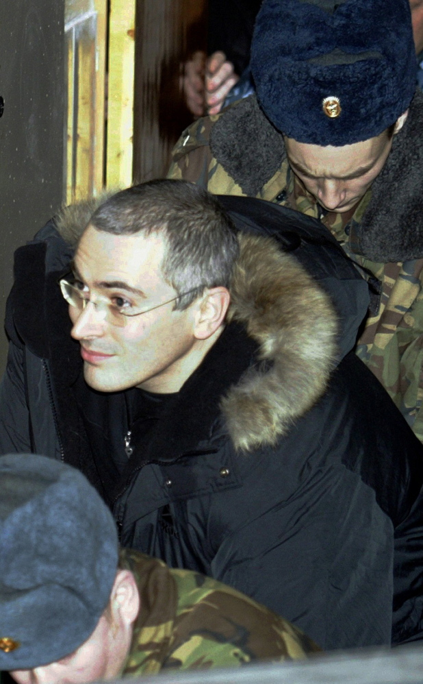 Mikhail Khodorkovsky, who founded Russia’s largest oil company and was once the nation’s richest man, leaves a Moscow court, escorted by police, in 2003.
